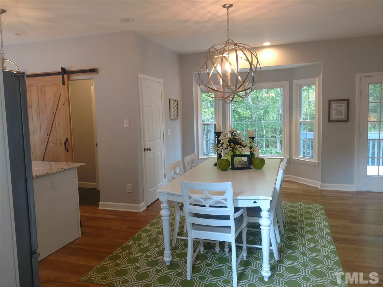 12101 Amoretto Way Raleigh, NC 27613 - Photo 2 of 15 a dining room with furniture a chandelier and wooden floor