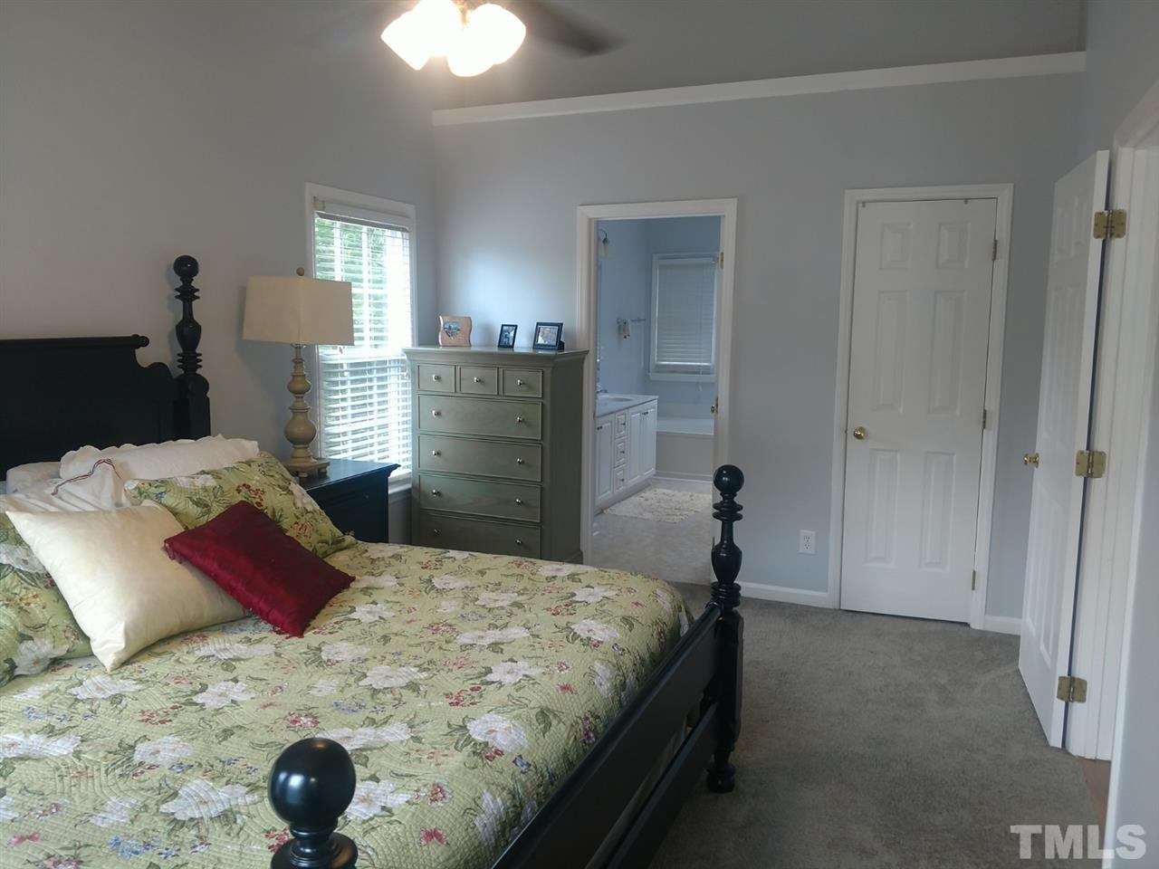 12101 Amoretto Way Raleigh, NC 27613 - Photo 8 of 15 a bedroom with a bed and a chandelier