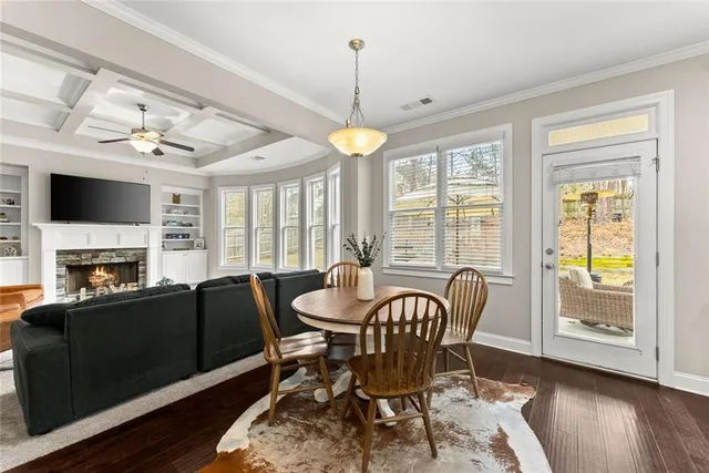 a dining room with stainless steel appliances kitchen island granite countertop a table chairs and a refrigerator