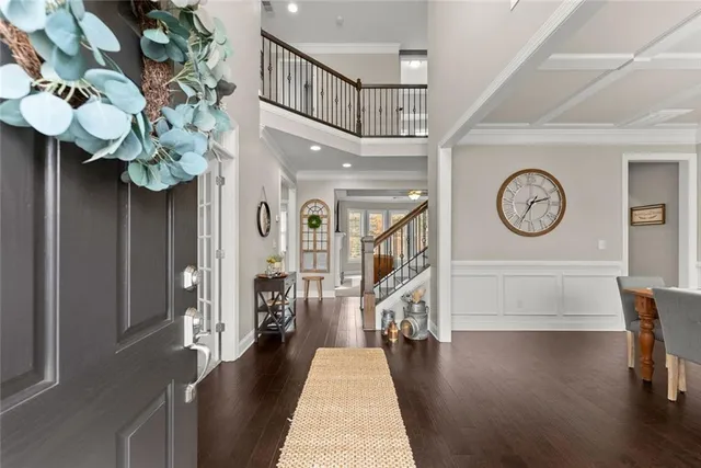 a dining room with wooden floor a chandelier a wooden table and chairs