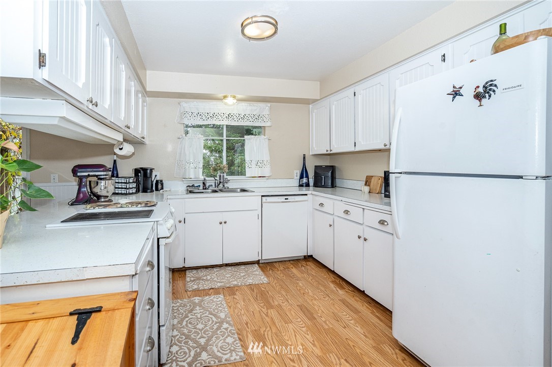 180 Winter Road Winlock, WA 98596 - Photo 14 of 40 a kitchen with white cabinets and white appliances