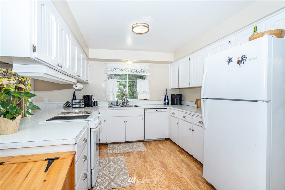 180 Winter Road Winlock, WA 98596 - Photo 6 of 40 a kitchen with granite countertop a sink stainless steel appliances and white cabinets