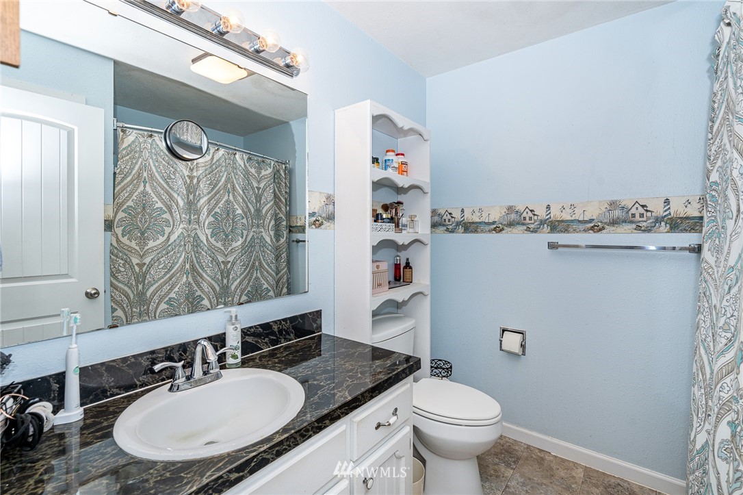 180 Winter Road Winlock, WA 98596 - Photo 9 of 40 a bathroom with a granite countertop toilet sink and mirror