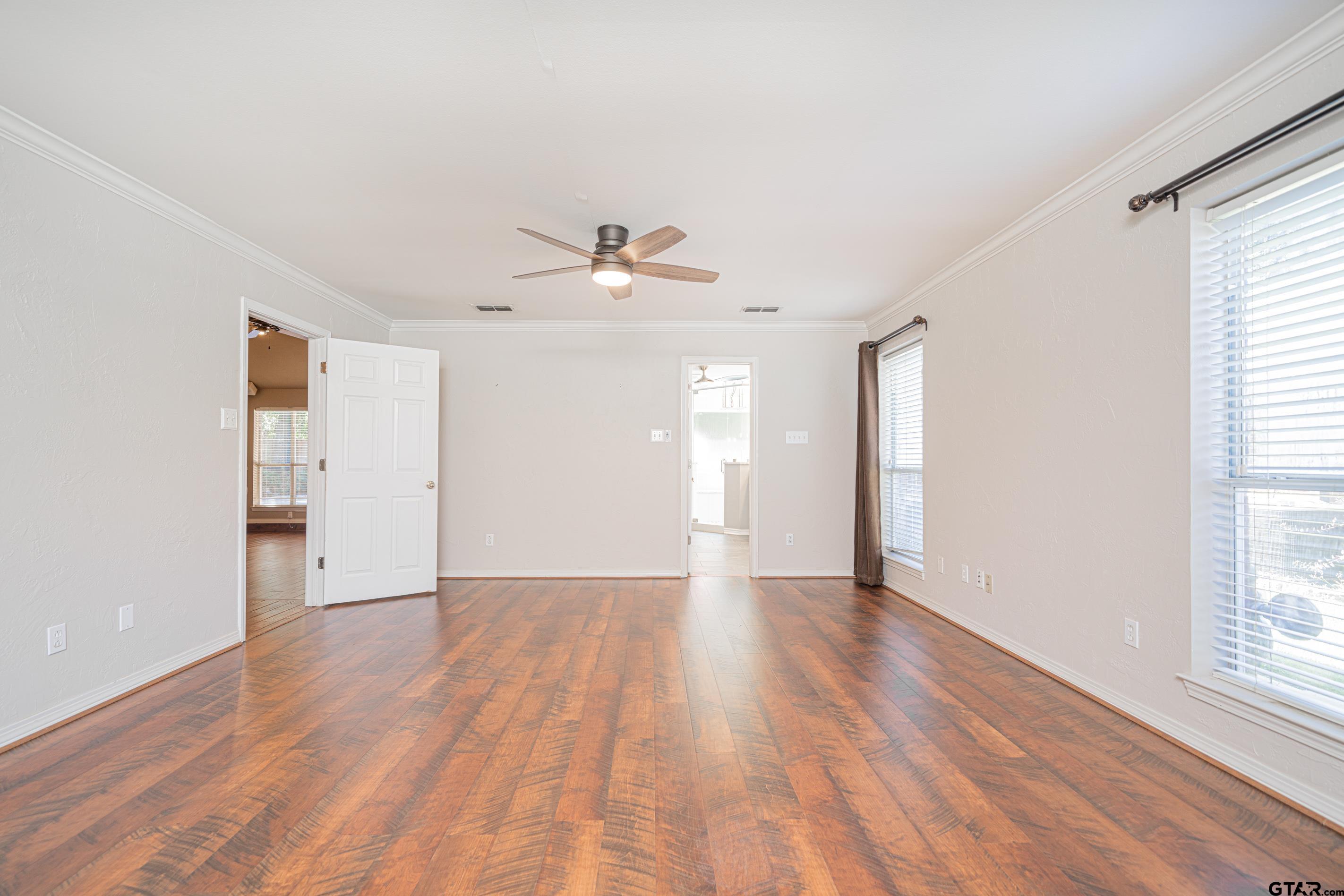 1704 West Northwood Court Longview, TX 75605 - Photo 11 of 32 an empty room with wooden floor and windows