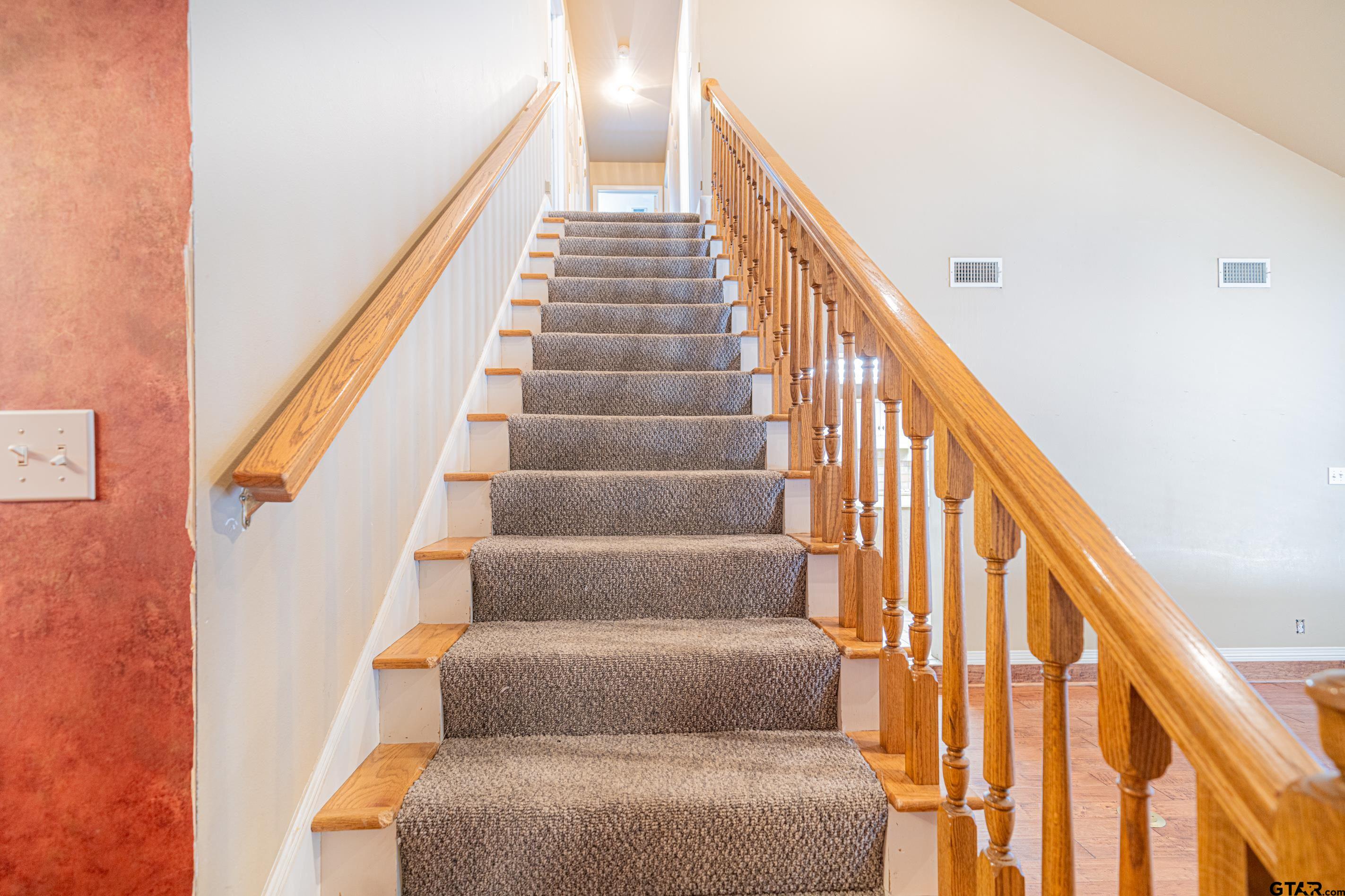 1704 West Northwood Court Longview, TX 75605 - Photo 15 of 32 a view of staircase with lots of frames on wall and a large window