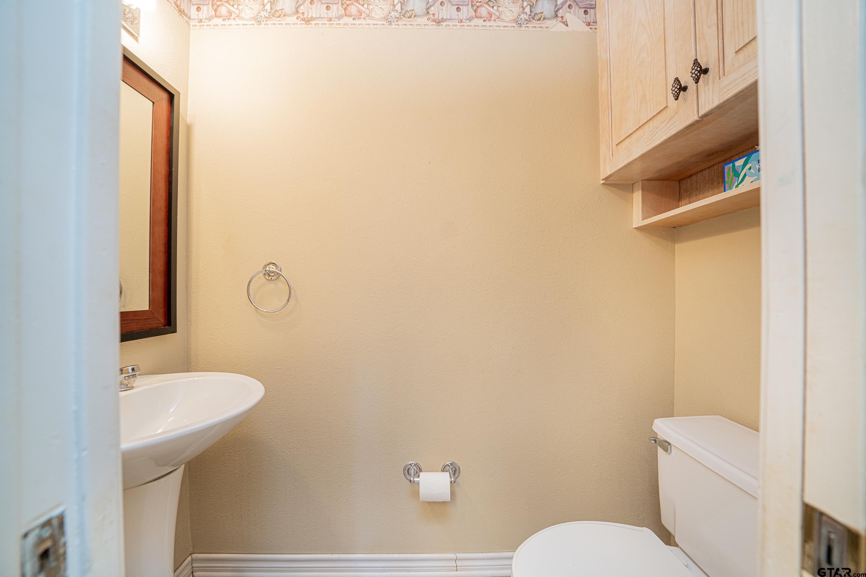1704 West Northwood Court Longview, TX 75605 - Photo 16 of 32 a bathroom with a sink a toilet a mirror and shower