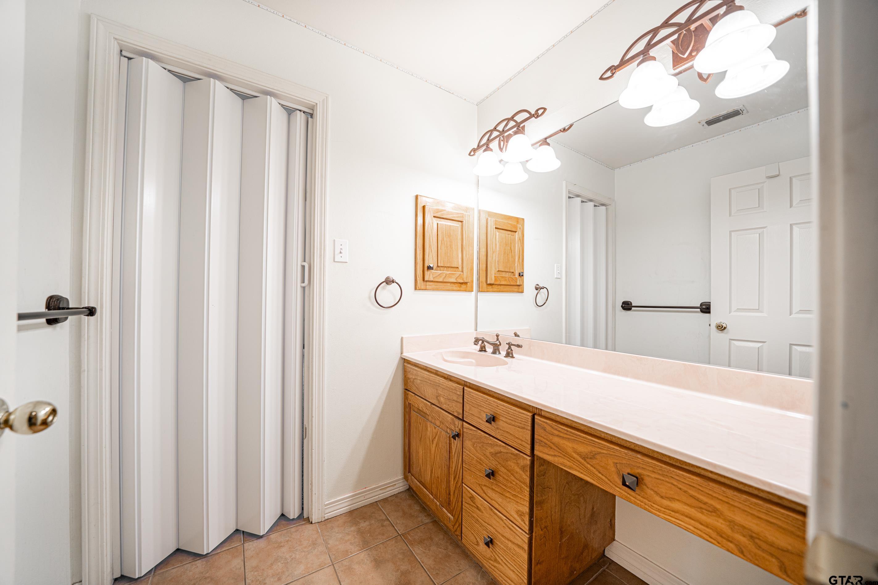 1704 West Northwood Court Longview, TX 75605 - Photo 22 of 32 a bathroom with a double vanity sink mirror and shower