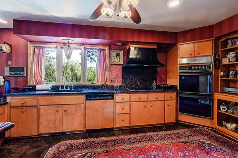a kitchen with stainless steel appliances granite countertop a sink stove and wooden cabinets