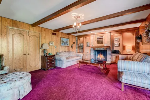 a living room with furniture a fireplace and a chandelier