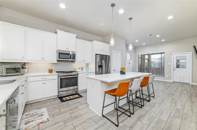 a large white kitchen with stainless steel appliances