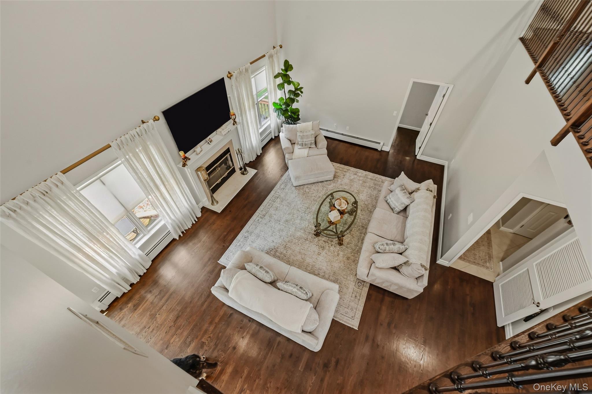 51 Meriwether Trail Congers, NY 10920 - Photo 22 of 50 Two-story living area featuring wood-finish flooring, a white fireplace with a mantle, and large windows with white drapery