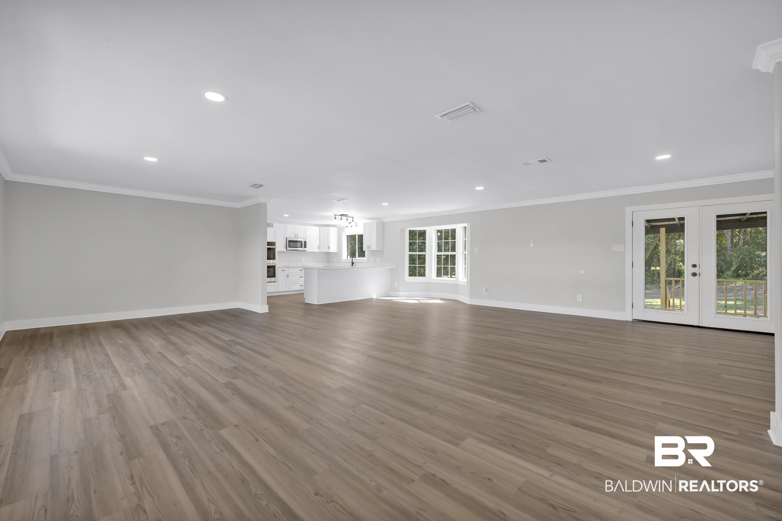 8351 Theodore Dawes Road Theodore, AL 36582 - Photo 7 of 46 Unfurnished living room featuring crown molding, light wood-style flooring, french doors, and recessed lighting