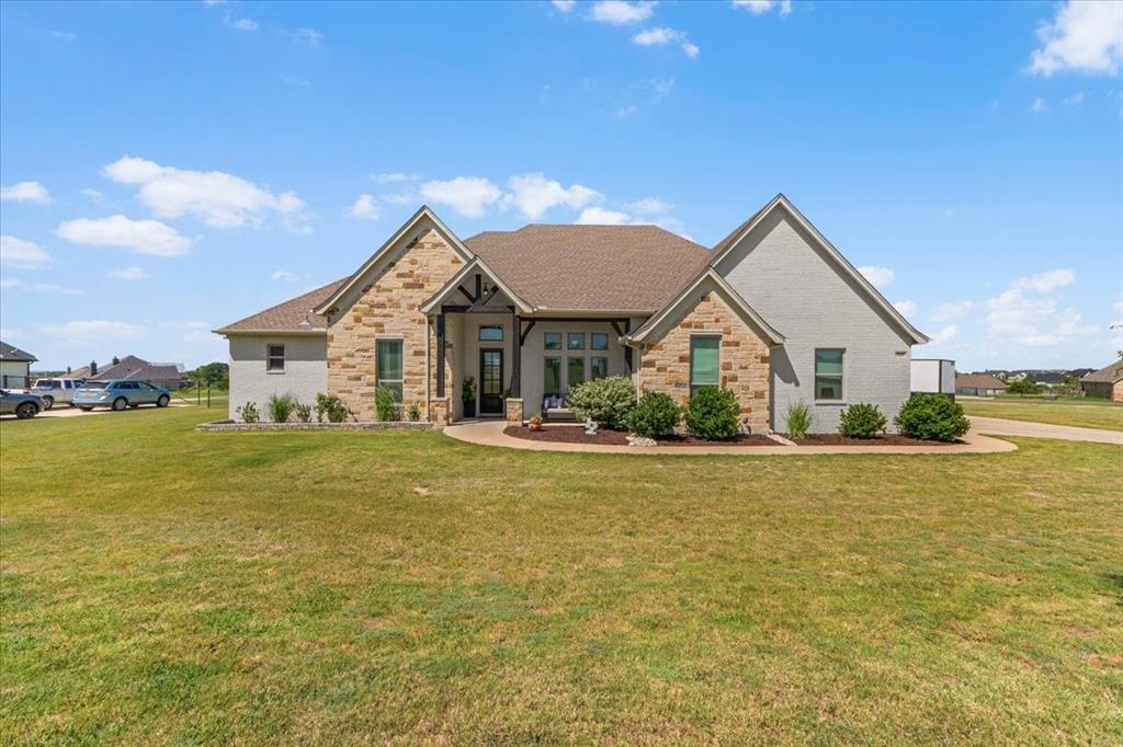 329 Palo Alto Drive Springtown, TX 76082 - Photo 2 of 34 Stone and painted brick exterior with manicured landscaping and a welcoming covered entry