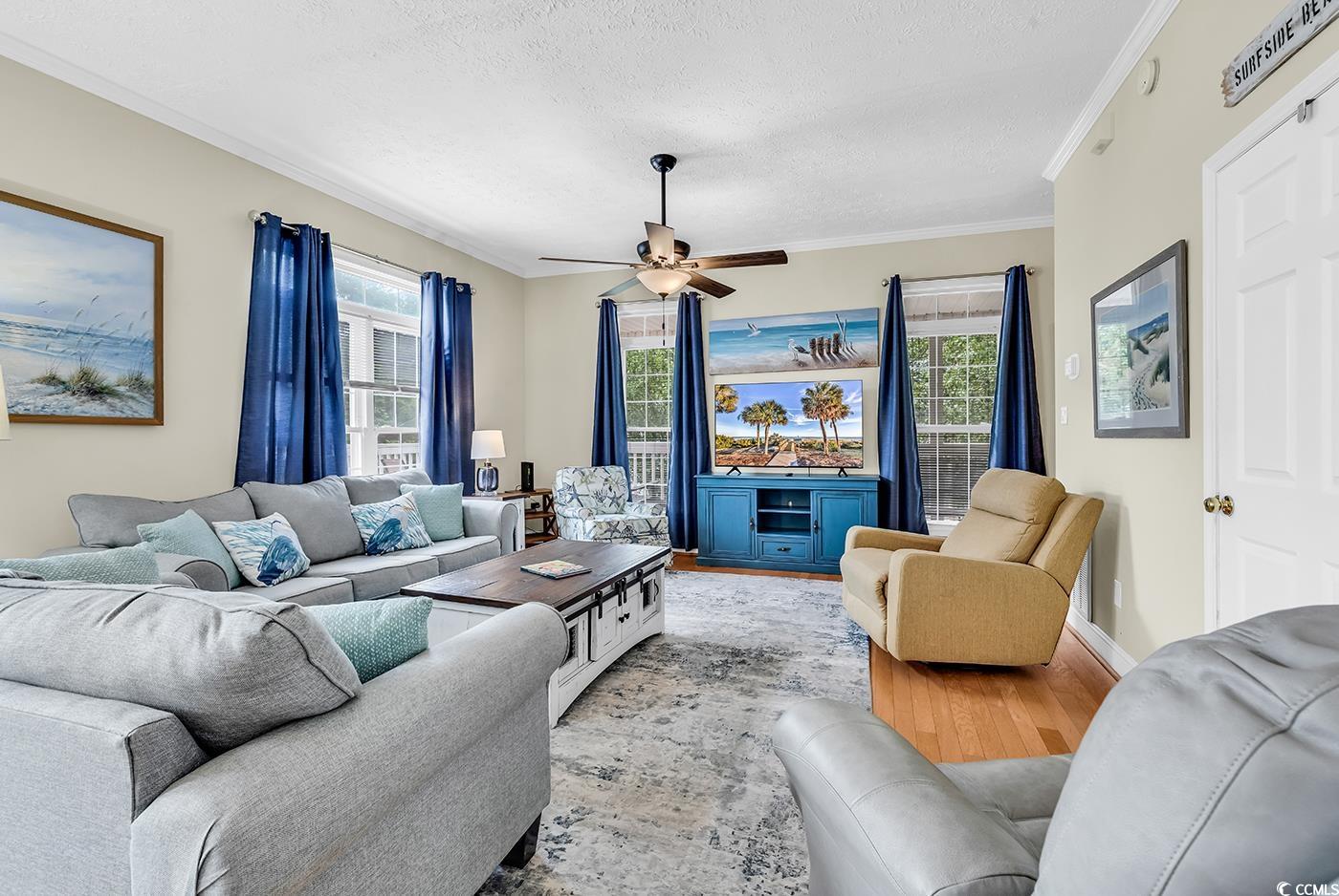 17 South Oak Drive Surfside Beach, SC 29575 - Photo 12 of 38 Living room with ornamental molding, light wood-style flooring, a textured ceiling, a ceiling fan, and baseboards