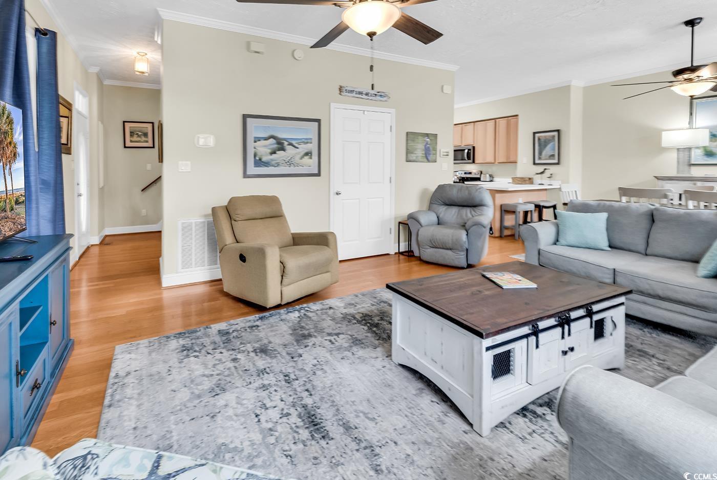 17 South Oak Drive Surfside Beach, SC 29575 - Photo 14 of 38 Living room featuring a ceiling fan, crown molding, light wood finished floors, and baseboards