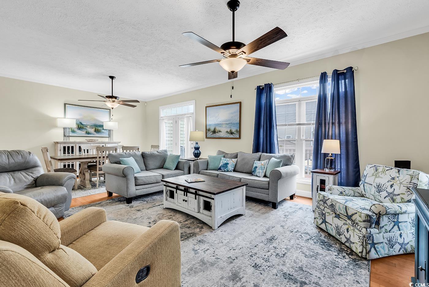17 South Oak Drive Surfside Beach, SC 29575 - Photo 15 of 38 Living area featuring ceiling fan, a textured ceiling, plenty of natural light, and light wood-style flooring