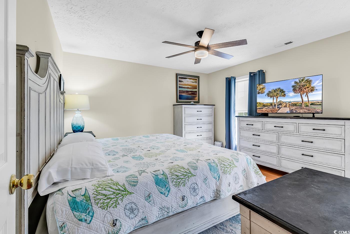 17 South Oak Drive Surfside Beach, SC 29575 - Photo 19 of 38 Bedroom featuring wood finished floors, a ceiling fan, and a textured ceiling