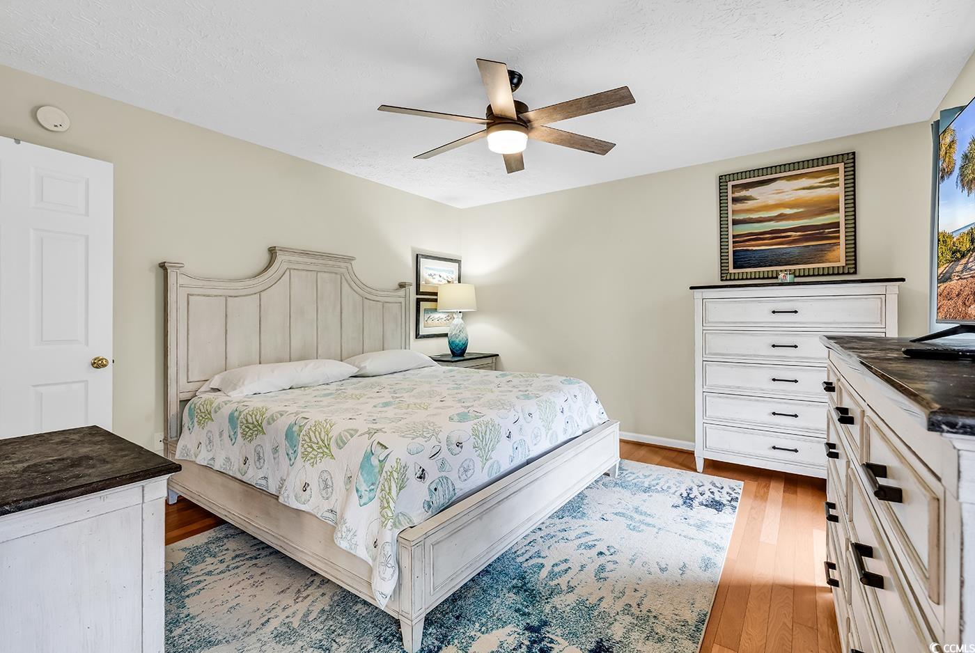 17 South Oak Drive Surfside Beach, SC 29575 - Photo 22 of 38 Bedroom with wood finished floors, ceiling fan, baseboards, and a textured ceiling