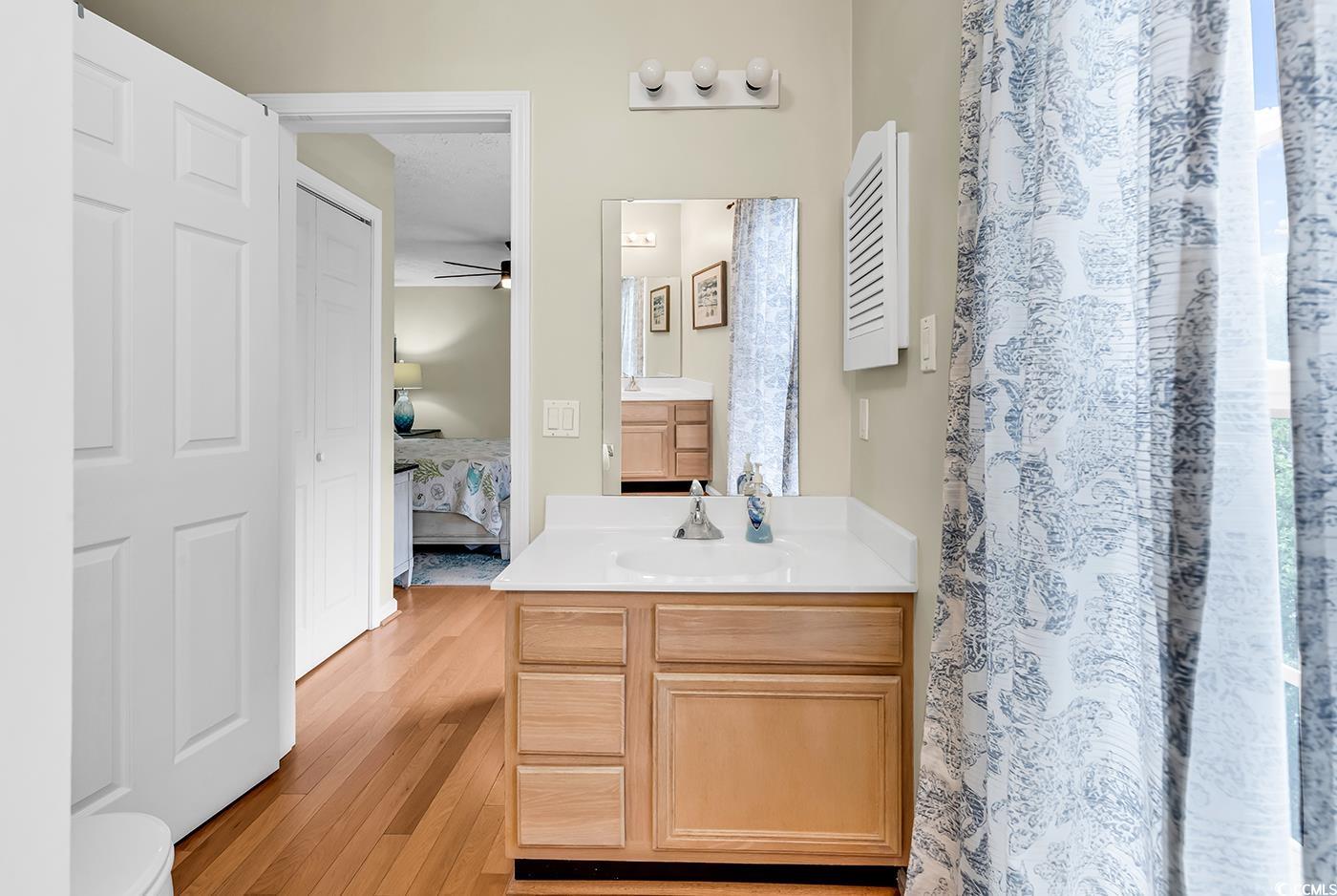 17 South Oak Drive Surfside Beach, SC 29575 - Photo 26 of 38 Bathroom featuring ensuite bathroom, wood finished floors, vanity, ceiling fan, and a shower with curtain