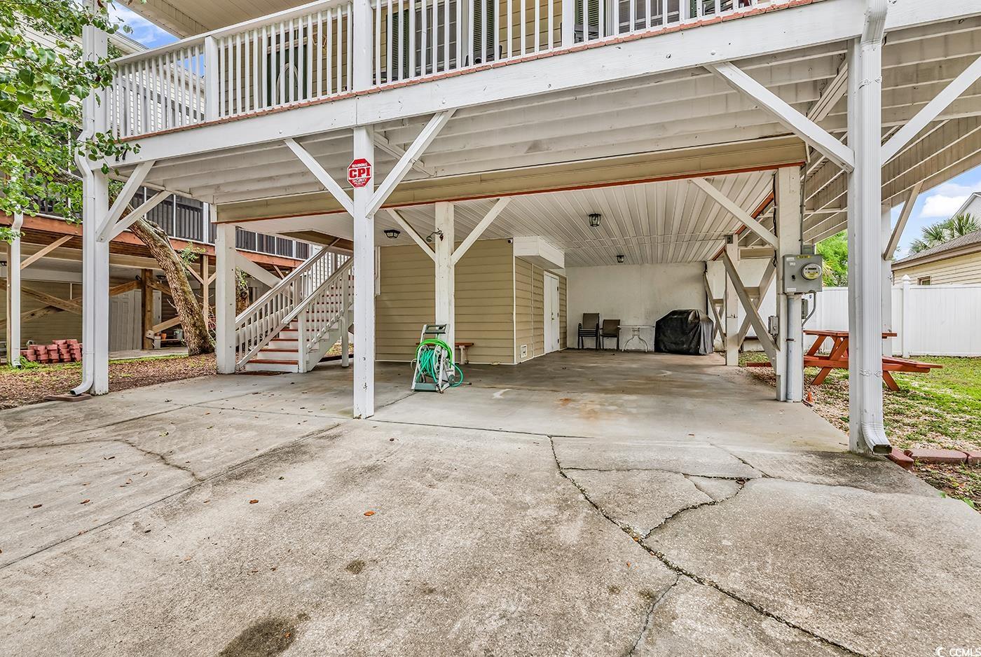 17 South Oak Drive Surfside Beach, SC 29575 - Photo 37 of 38 View of parking / parking lot with concrete driveway, a carport, stairs, and fence