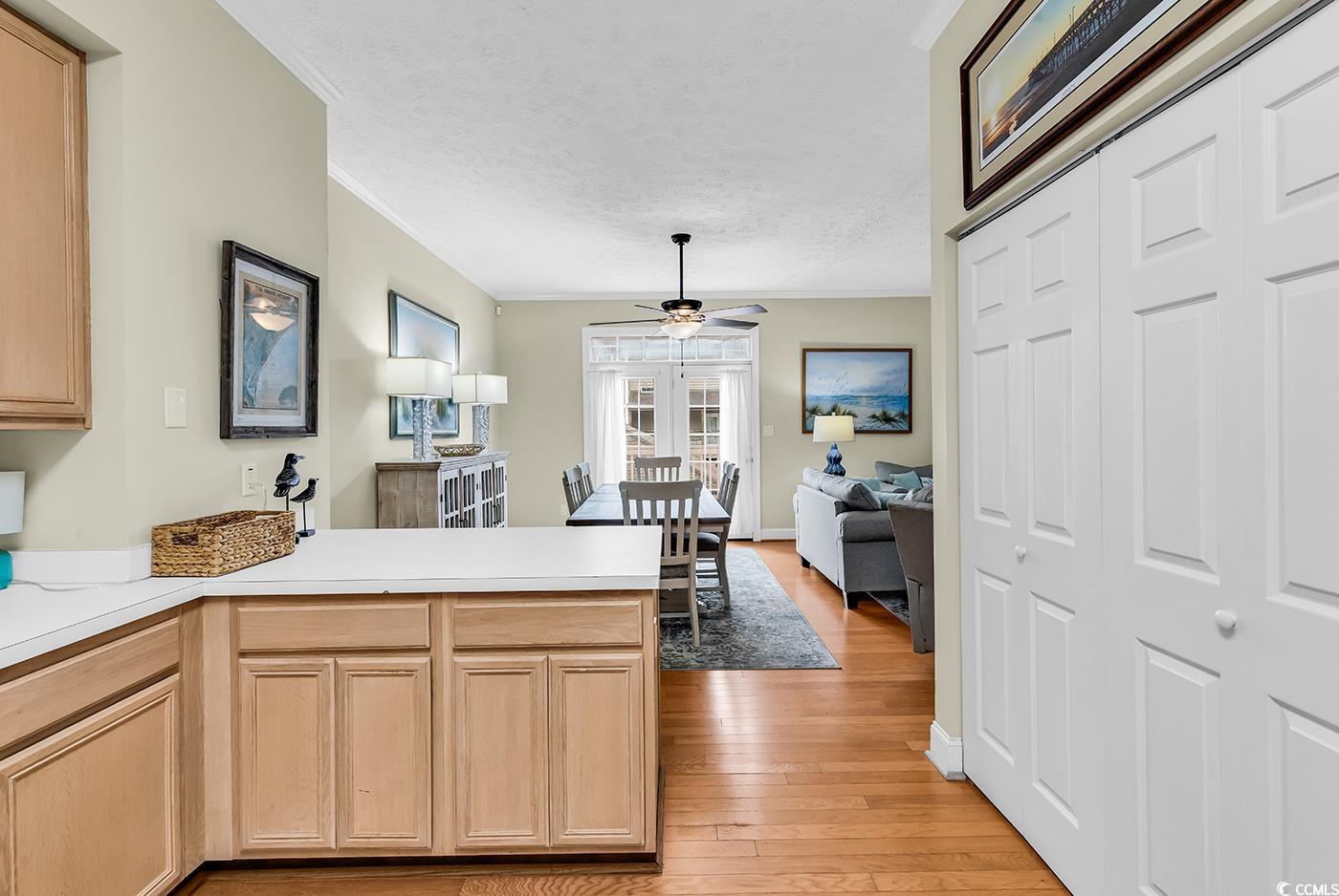 17 South Oak Drive Surfside Beach, SC 29575 - Photo 6 of 38 Kitchen featuring a peninsula, light wood finished floors, crown molding, ceiling fan, and light countertops
