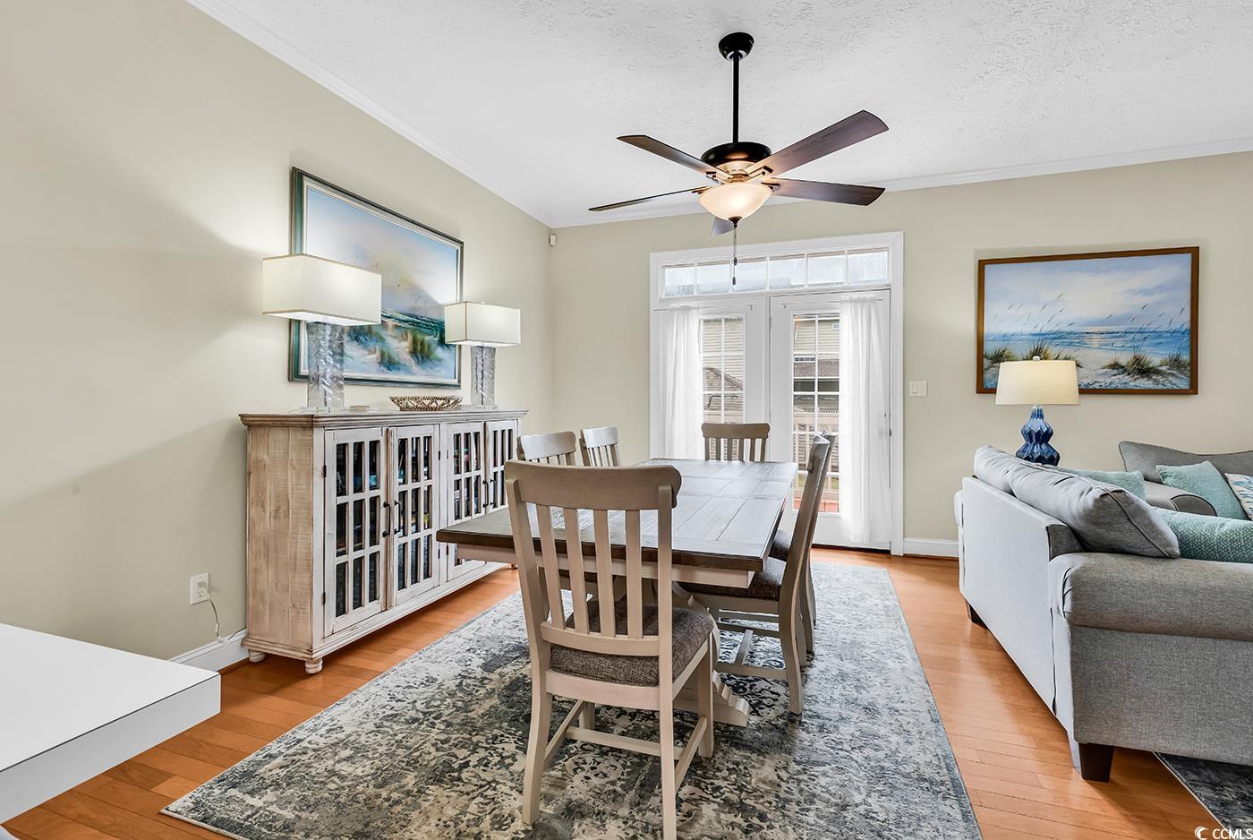 17 South Oak Drive Surfside Beach, SC 29575 - Photo 7 of 38 Dining space with a ceiling fan, crown molding, light wood-type flooring, baseboards, and a textured ceiling