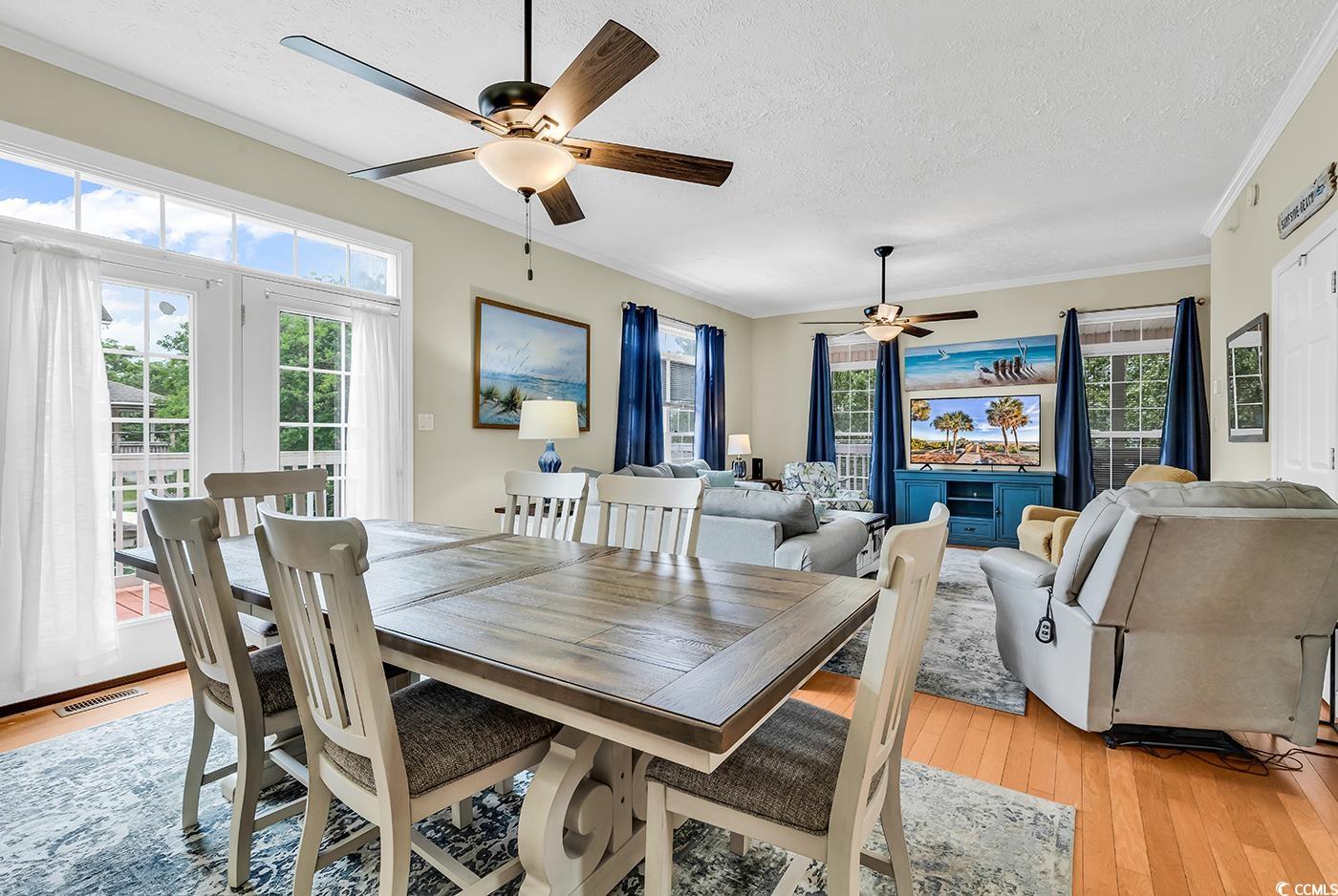 17 South Oak Drive Surfside Beach, SC 29575 - Photo 8 of 38 Dining area with a ceiling fan, a textured ceiling, ornamental molding, light wood finished floors, and plenty of natural light