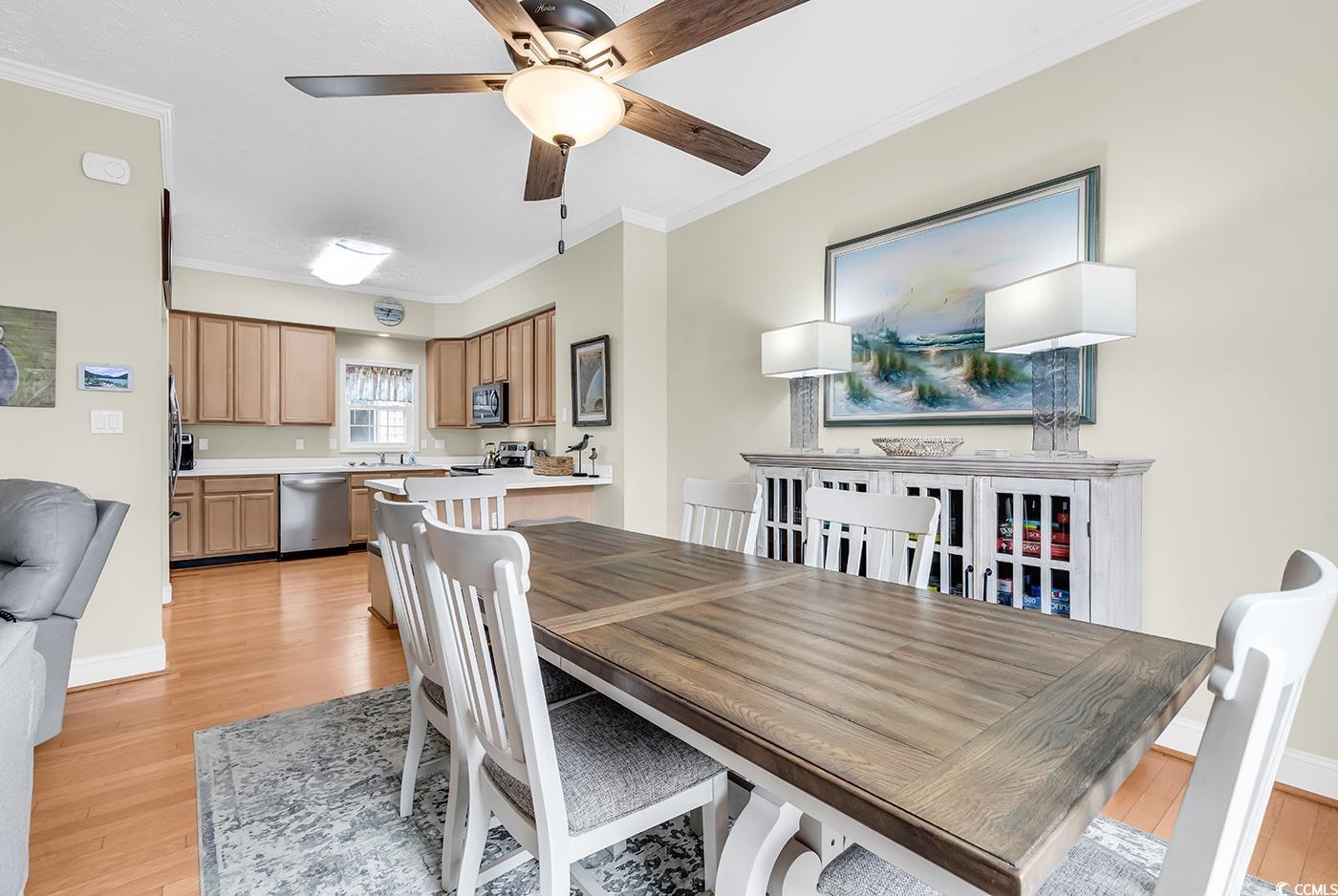 17 South Oak Drive Surfside Beach, SC 29575 - Photo 10 of 38 Dining room with light wood-style floors, ornamental molding, a ceiling fan, and baseboards