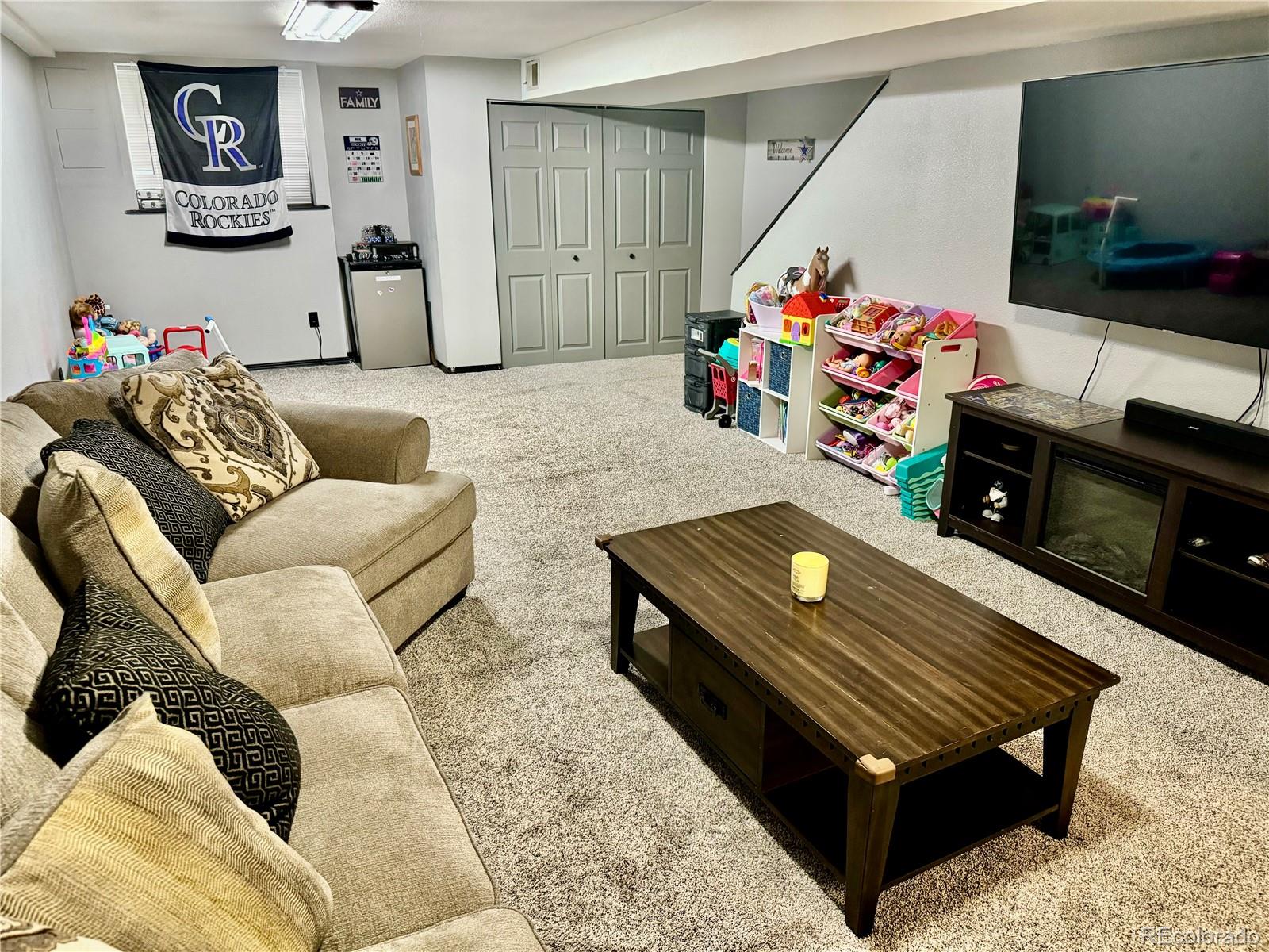 1254 South Reed Street, Unit 1 Lakewood, CO 80232 - Photo 15 of 19 a living room with furniture and a flat screen tv