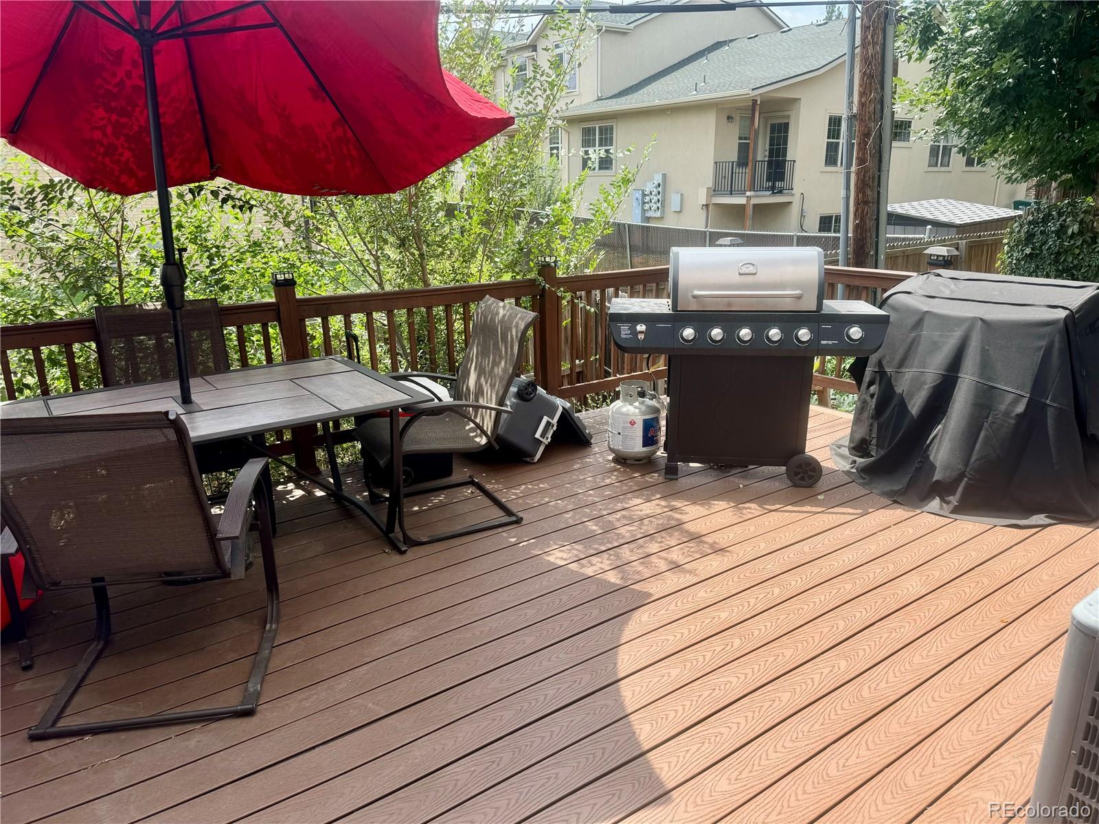 1254 South Reed Street, Unit 1 Lakewood, CO 80232 - Photo 18 of 19 a view of a patio with table and chairs under an umbrella