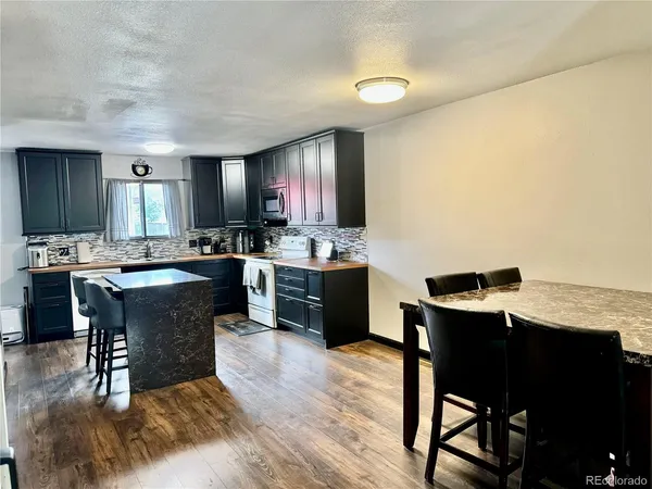 a kitchen with a dining table chairs and view kitchen