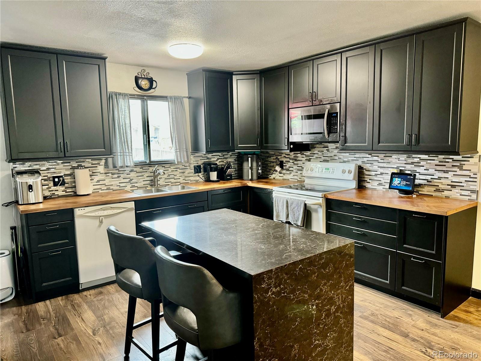 1254 South Reed Street, Unit 1 Lakewood, CO 80232 - Photo 6 of 19 a kitchen with a sink stove and chairs