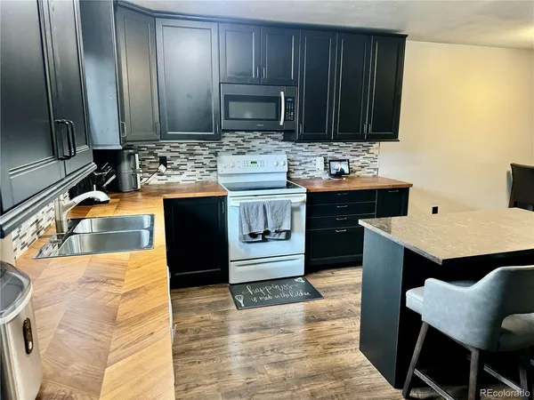 a kitchen with stainless steel appliances kitchen island granite countertop a sink stove and cabinets