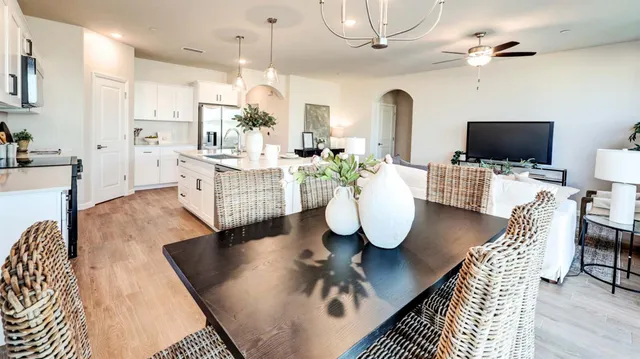 a living room with dining table furniture and a flat screen tv