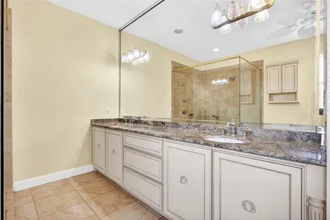 a bathroom with a granite countertop sink vanity mirror and toilet