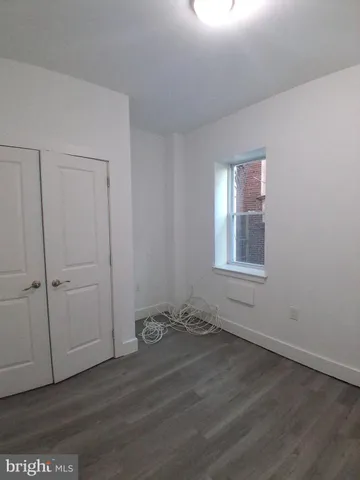 a view of an empty room with closet and a window