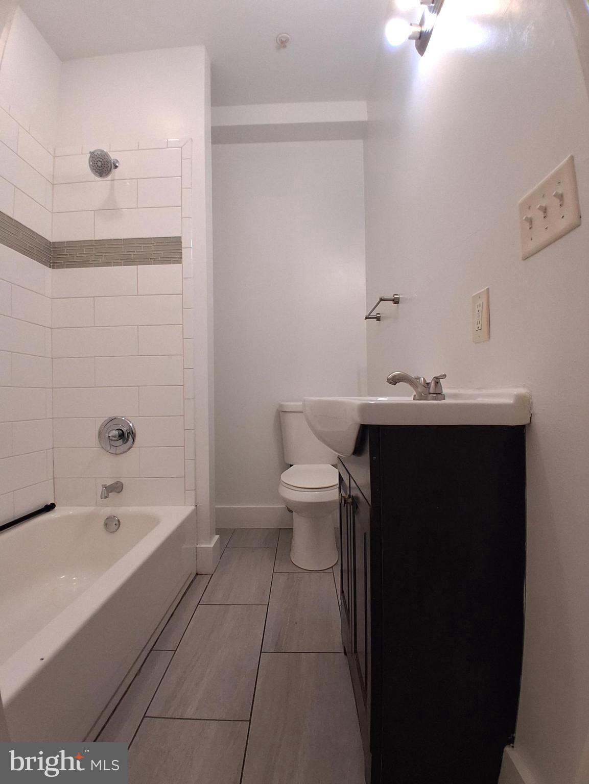 6104 Market Street, Unit 2 Philadelphia, PA 19139 - Photo 9 of 11 a bathroom with a sink a toilet and bathtub