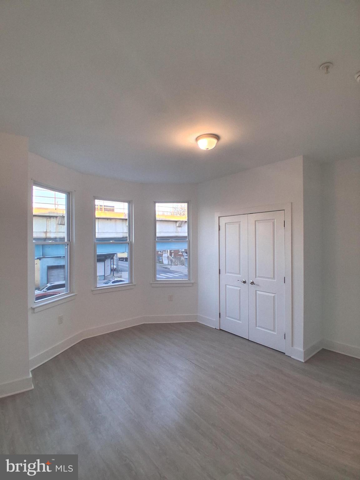 6104 Market Street, Unit 2 Philadelphia, PA 19139 - Photo 10 of 11 an empty room with wooden floor and windows