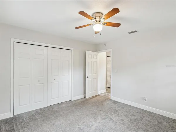an empty room with a window and a fan