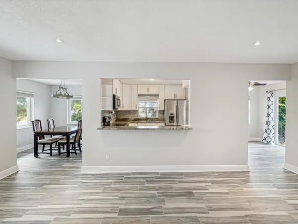 a view of dining room kitchen with stainless steel appliances granite countertop furniture and a living room