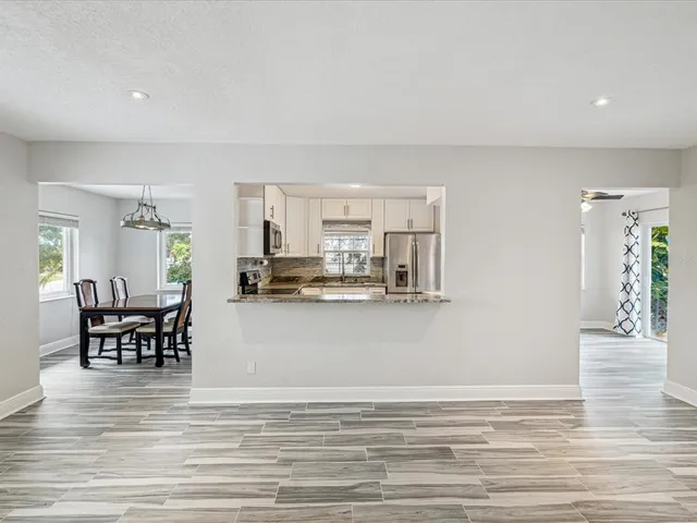a view of dining room kitchen with stainless steel appliances granite countertop furniture and a living room