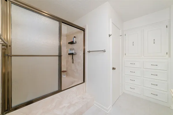 a view of a refrigerator in kitchen and white cabinets