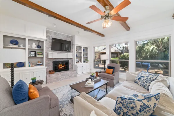 a living room with furniture fireplace and a large window