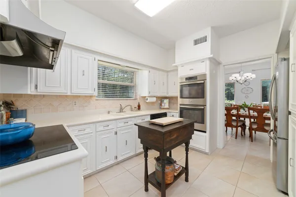 a kitchen with cabinets and chairs in it