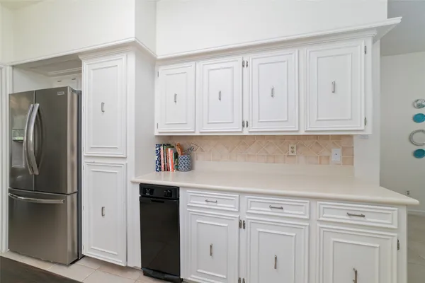 a kitchen with stainless steel appliances white cabinets and a refrigerator
