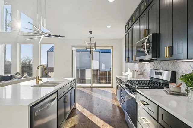 a kitchen with stainless steel appliances granite countertop a sink and stove