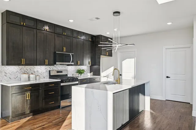 a kitchen with a sink cabinets and wooden floor
