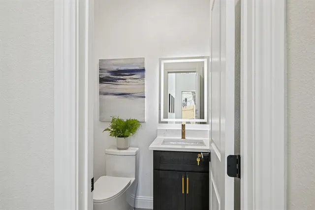 a bathroom with a toilet a sink and mirror