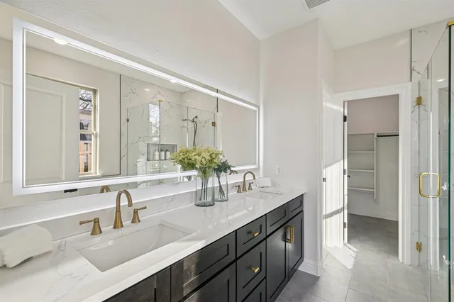 a bathroom with a double vanity sink mirror and next to a white cabinet