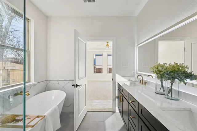 a bathroom with a double vanity sink a mirror and next to a window